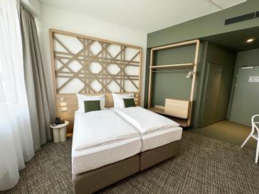ARCOTEL AQ Wien | Wien | Cozy hotel room at ARCOTEL AQ in Vienna with stylish interior and comfortable bed.